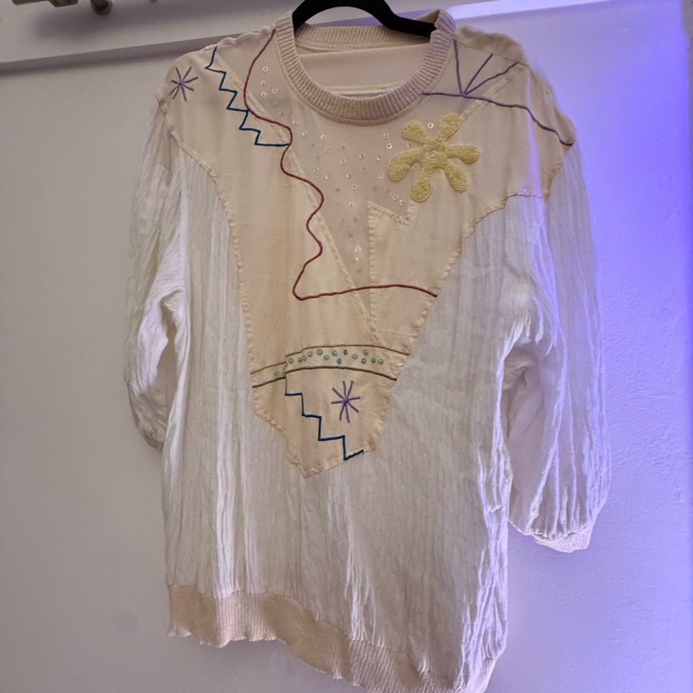 This piece is an OSOS / Oso-style embroidered pullover with: